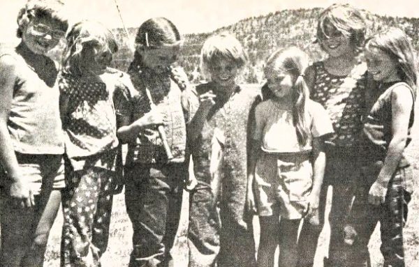 A group of young girls admire a fish that one has caught.