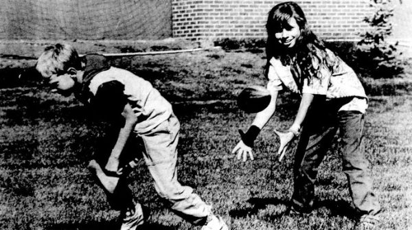 A boy and girl practice hiking a football