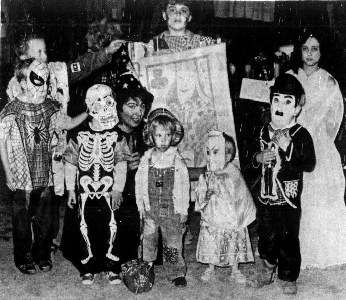 A group of children pose in their Halloween costumes.