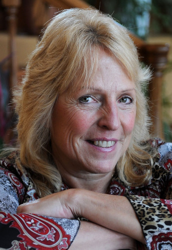 Headshop of Ellen Hopkins with her arms crossed in front of her wearing a paisley button front shirt.