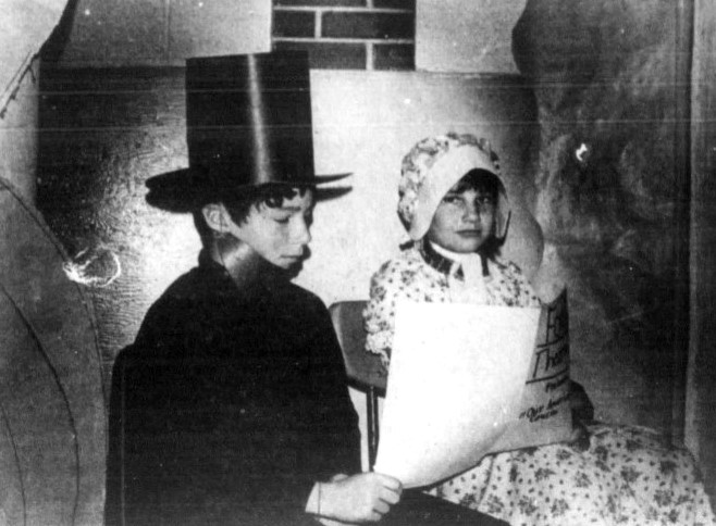 A boy and a girl perform as Abe and Mary Lincoln in an elementary school play.