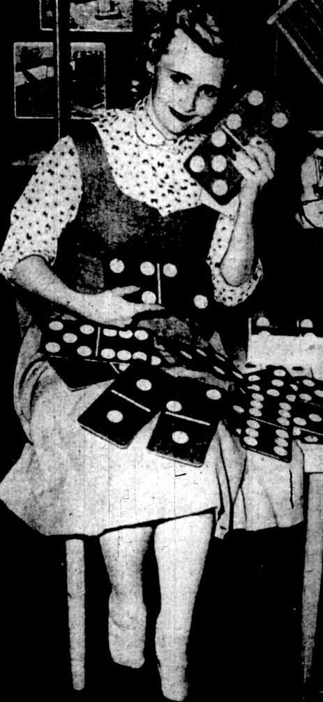 A woman poses with book-sized dominoes.