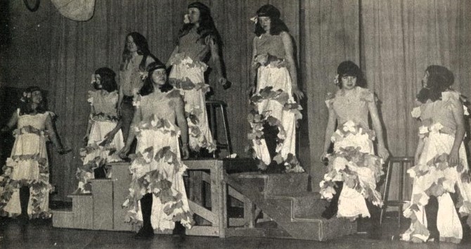 8 young women in historic French-style costumes  rehearse on stage.