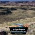 A national parks sign reading "Dominguez Escalante National Conservation Area" in front of a canyon landscape.